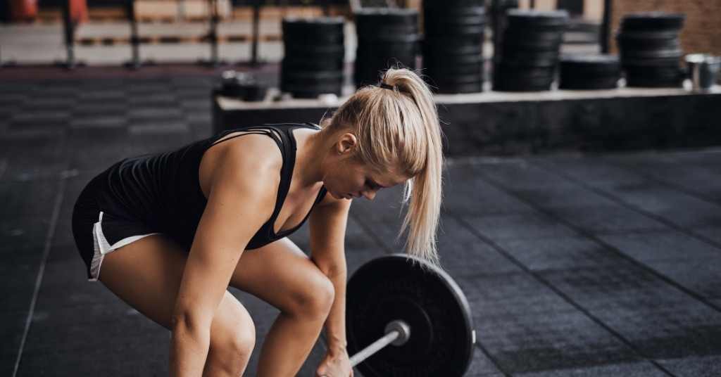 girl in gym doing deadlift strength training