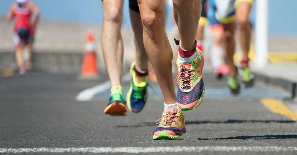 runners legs running on road in 10K running race